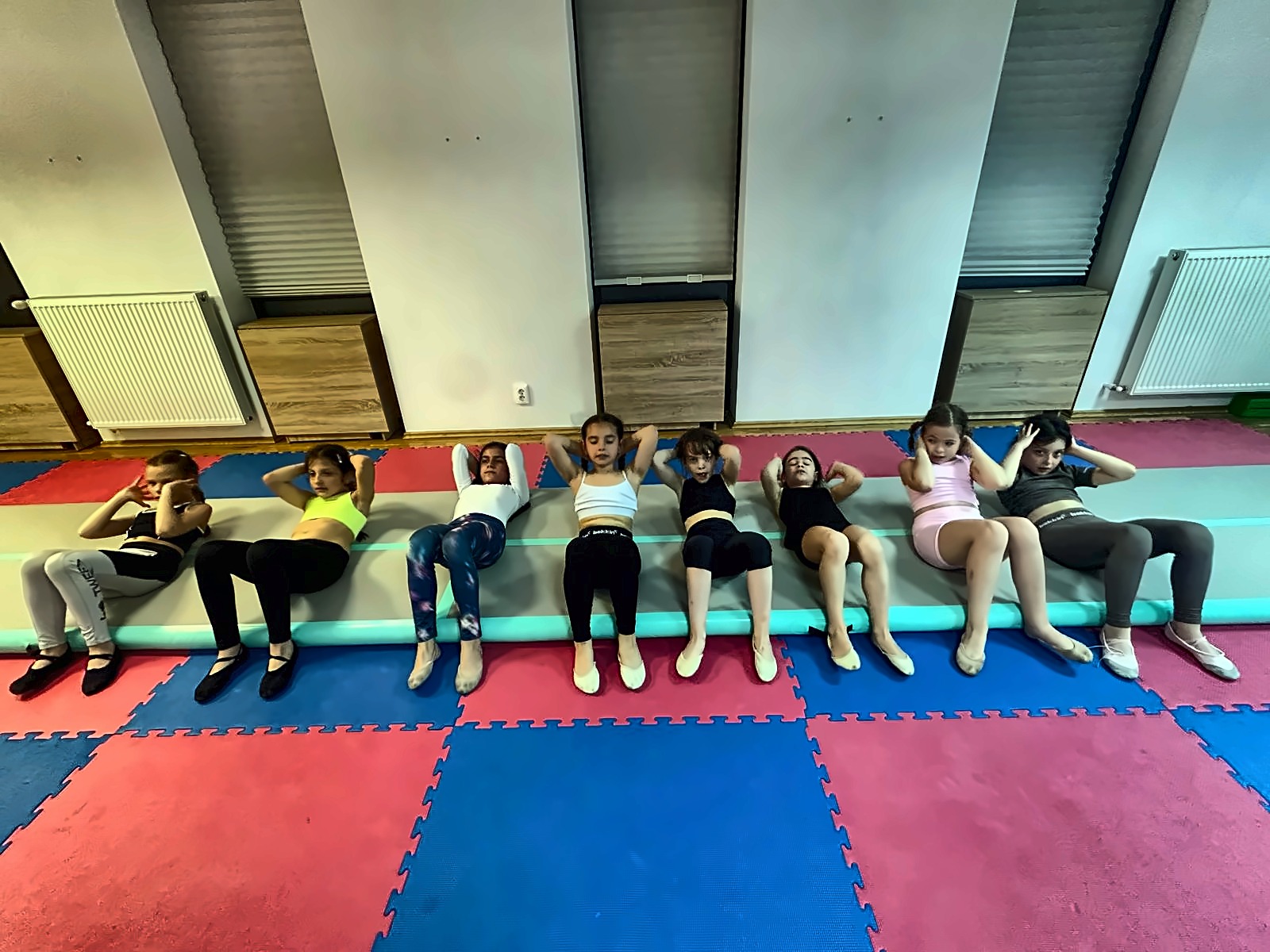 Grupă de copii la exerciții pe saltea în sala Happy Star